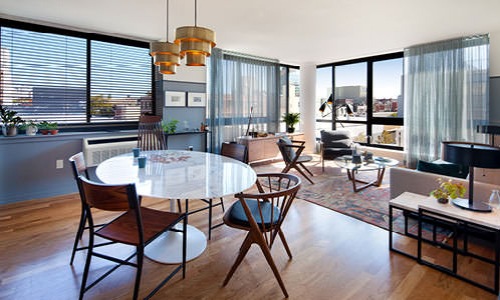 dining room open to living area surrounded by oversized windows