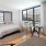 spacious bedroom with ac unit under oversized window and sitting area